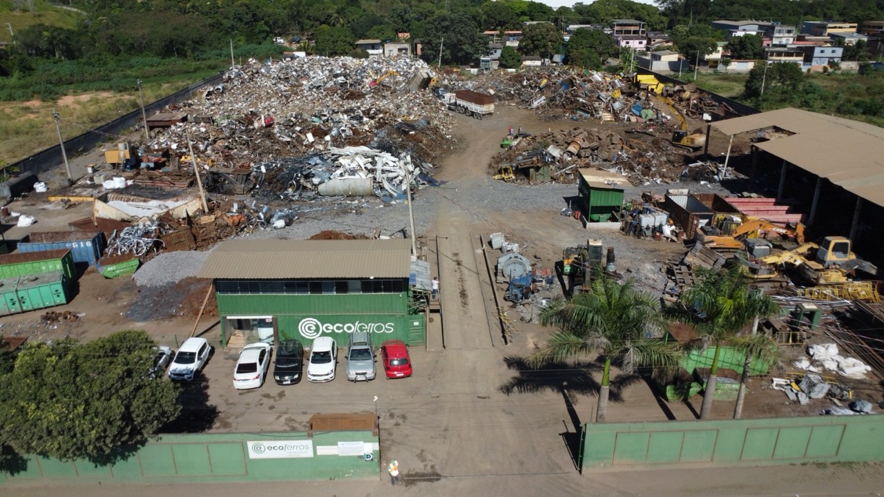Pátio da Ecoferros com a marca na fachada, materiais e equipamentos